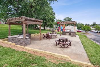 A park with a picnic table and a playground.